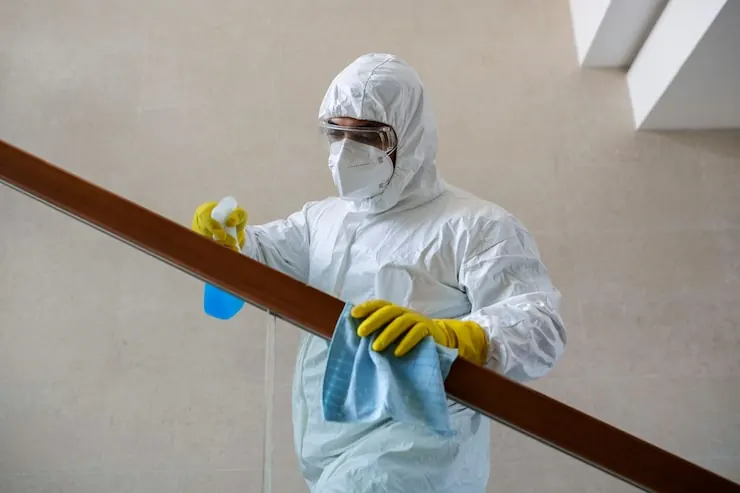 Technician in protective gear treating a commercial space